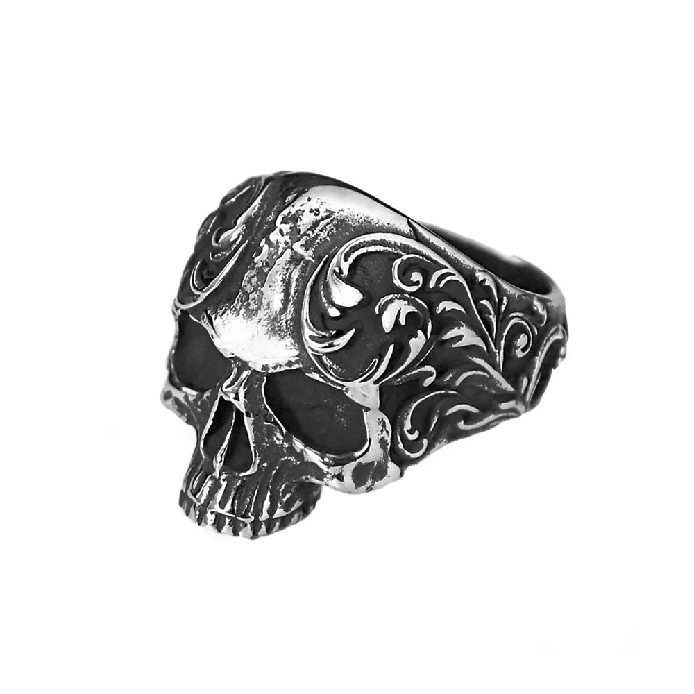 A silver-toned gothic carved skull ring featuring intricate scrollwork details.