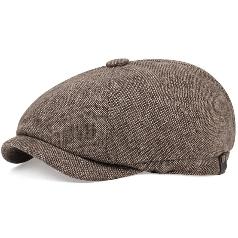 A close-up view of a vintage retro newsboy cap in a brown tweed fabric.