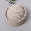 A beige straw pillbox sun hat with a wide brim shown from above.
