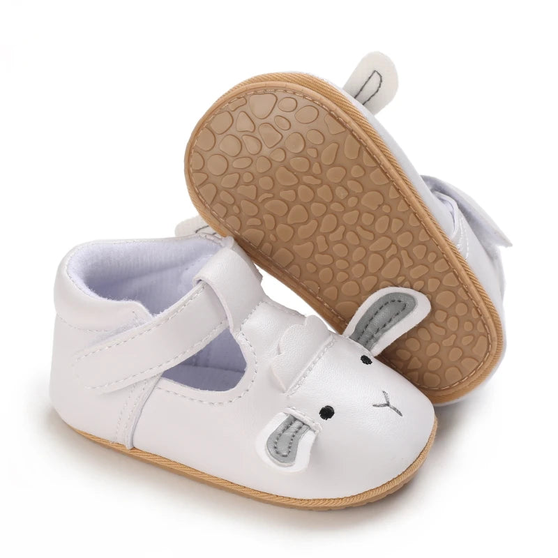 A pair of white baby first walker shoes with light brown non-slip soles and gray accents.