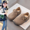 A young girl models retro non-slip moccasin shoes with hook-and-loop closure.