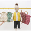 A mannequin wears a yellow quilted vest over a white shirt and dark pants, displayed on a hanger.