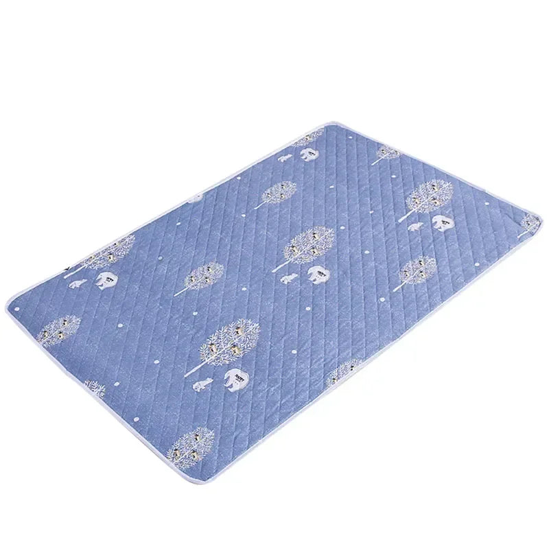 Light blue quilted mattress protector featuring a pattern of small white floral and cartoon designs.