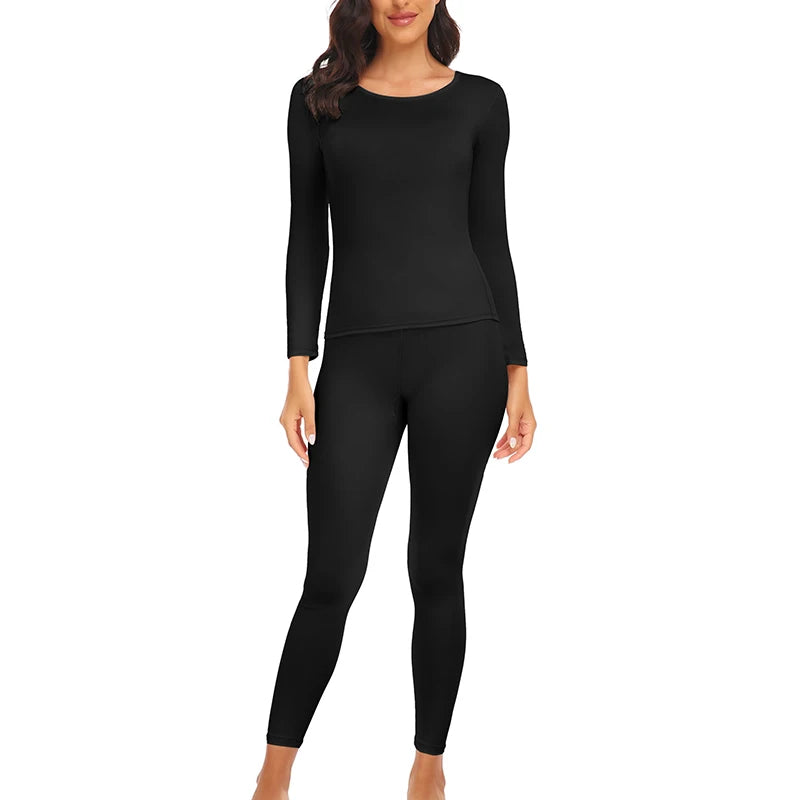 A woman wearing a black long-sleeved thermal top and matching full-length leggings.