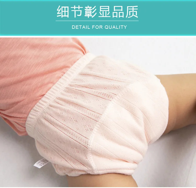 Close-up of pink organic cotton baby training pants being worn on a child's leg.