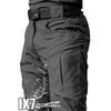 Vista cercana de pantalones cargo gris oscuro con múltiples bolsillos y un cinturón negro.