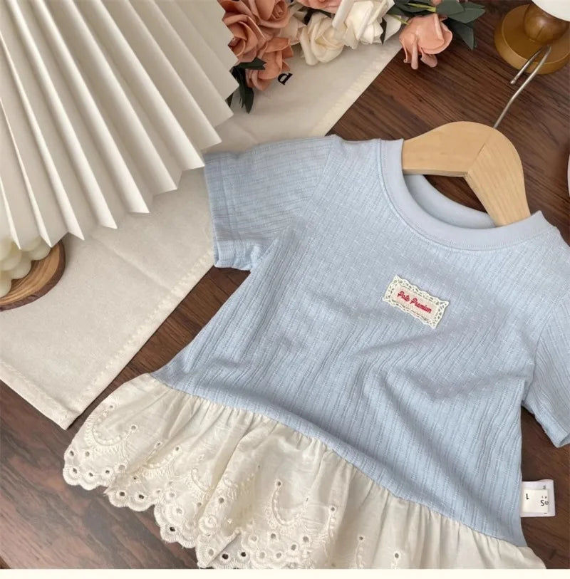 Light blue girls cotton short sleeve tee with a lace hem and white trim displayed on a wooden hanger.