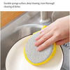A hand is using a durable and highly elastic mesh cover sponge surface to clean a plate in a kitchen sink.