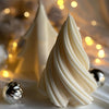 A white silicone mold shaped like a geometric Christmas tree is shown with soft bokeh lights in the background.