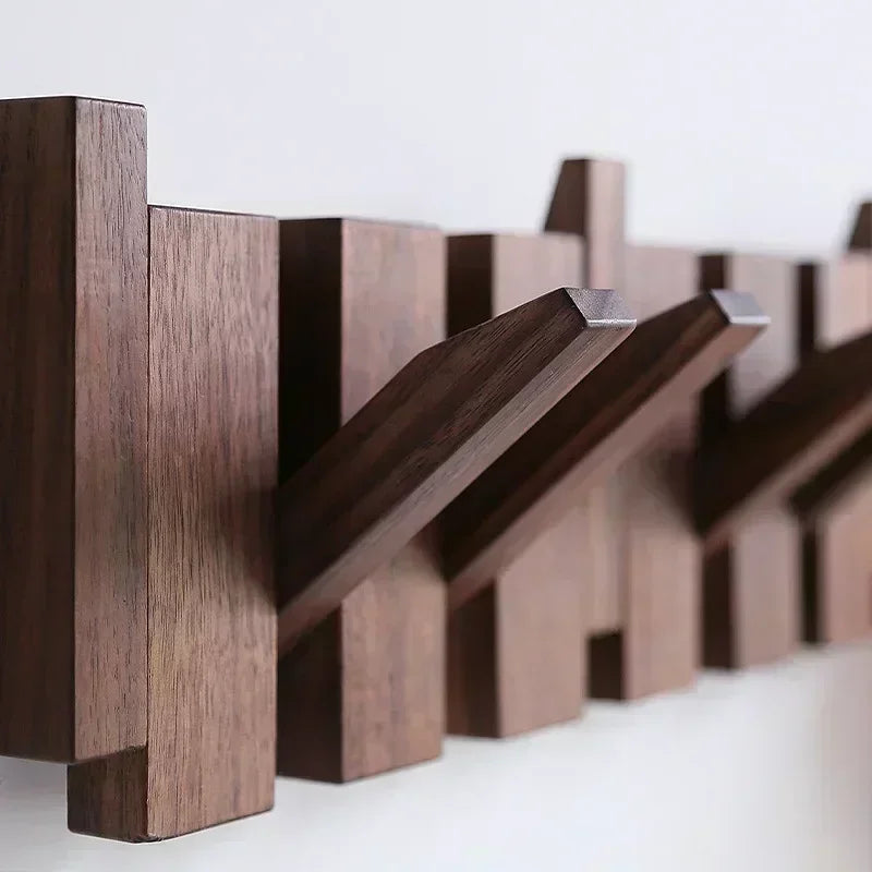Wandgarderobe aus dunkelbraunem Massivholz mit acht abgewinkelten Haken.