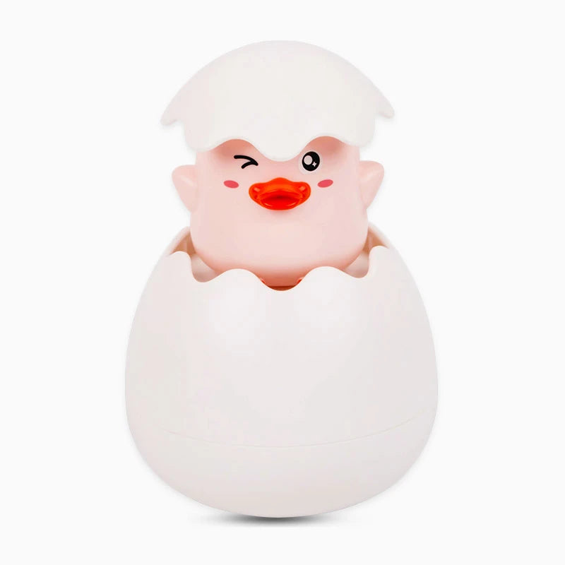 A white bath toy shaped like a duck or penguin with a smiling face emerging from an egg-like base.