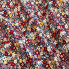 Close-up of floral 100% cotton poplin fabric in shades of red, pink, yellow, and blue.