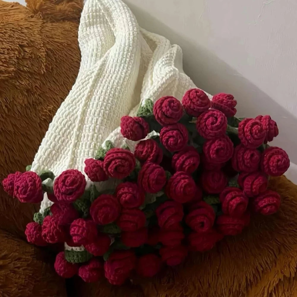 باقة من الورود المحبوكة يدويًا ثلاثية الأبعاد بألوان الأحمر والوردي على سطح مخملي بني
