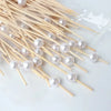 A collection of elegant pearl-like beads threaded onto bamboo skewers for appetizers and desserts.