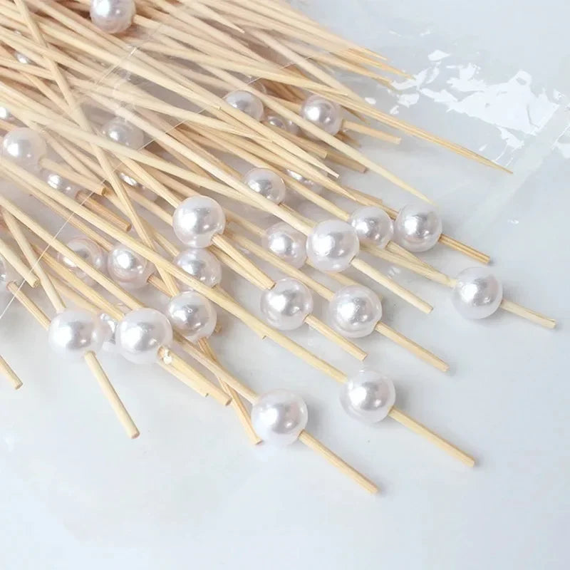 A collection of elegant pearl-like beads threaded onto bamboo skewers for appetizers and desserts.