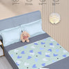 A light blue baby mattress protector with a cute cartoon design is shown on a gray bed, surrounded by features like moisture 