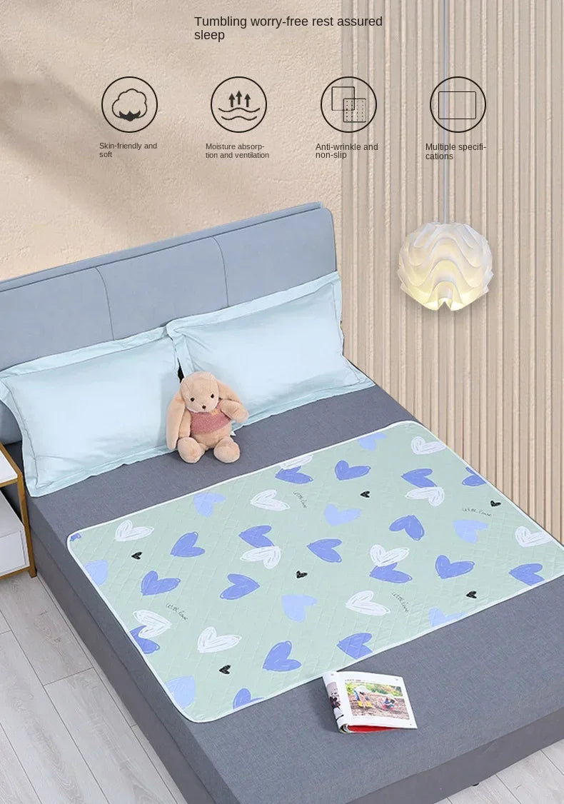 A light blue baby mattress protector with a cute cartoon design is shown on a gray bed, surrounded by features like moisture 