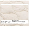 A close-up of a white quilted fabric showing the texture and stitching.