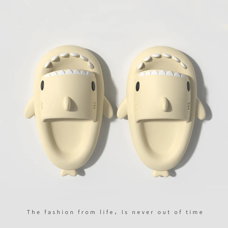 Et par lyse beige sklisandaler med haidesign i EVA, sett ovenfra