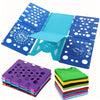 A blue clothes folding board with multiple folding panels and a stack of purple, green, yellow, and blue laundry folders.