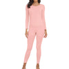 A woman wearing a long-sleeved pink thermal top and matching full-length leggings.