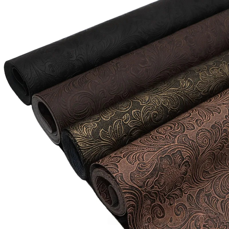 Rolls of vintage floral textured faux leather fabric in various shades of brown and black.