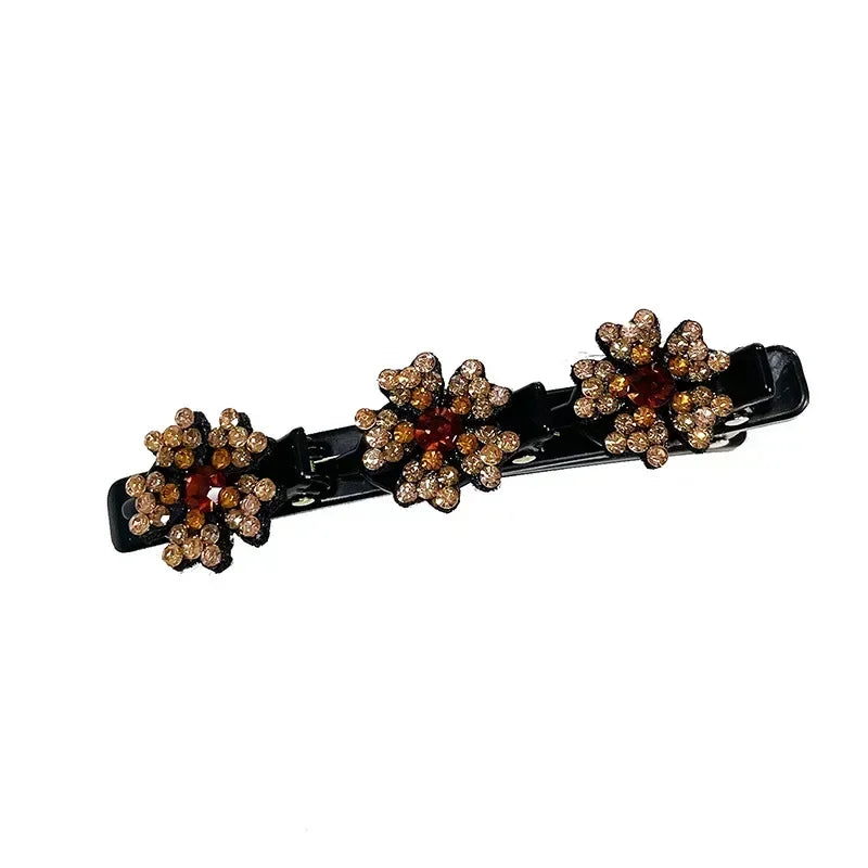 Clip de cabello negro con múltiples grupos de adornos florales dorados y bronce