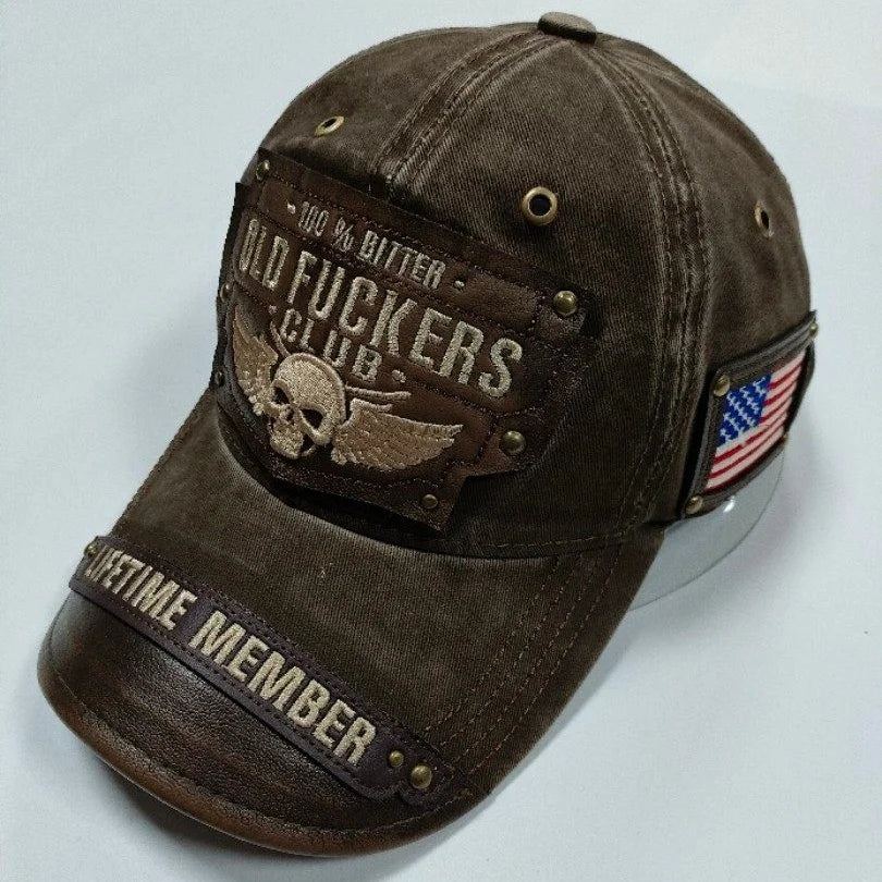 En mørk brun, slitt baseballcaps i bomull med brodert tekst som sier OLD FUCKERS CLUB og en liten amerikaner