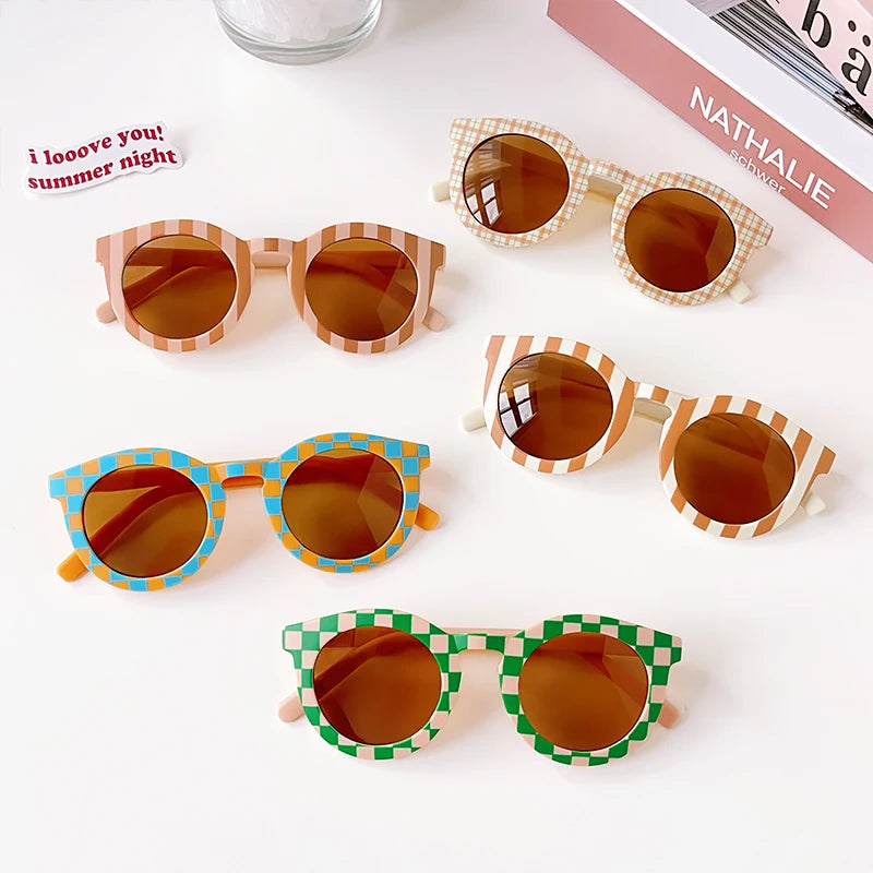 A collection of colorful kids sunglasses featuring various frames and lenses on a white background.