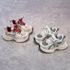 A pair of red and white breathable mesh kids' running sneakers with flexible cushioning resting on a gray surface.