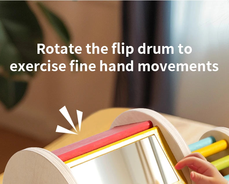 A child's hand is rotating a wooden flip drum to exercise fine hand movements.