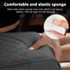 A hand is squeezing a white elastic sponge inner core inside a gray quilted cushion.