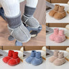 A collection of baby suede leather winter booties in various colors including pink, red, blue, and beige.