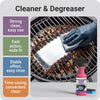 Une main essuie une grille de barbecue avec une éponge argentée en utilisant un spray nettoyant et dégraissant.