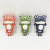 Three ceramic frog toys in peach, green, and gray colors for toddlers.