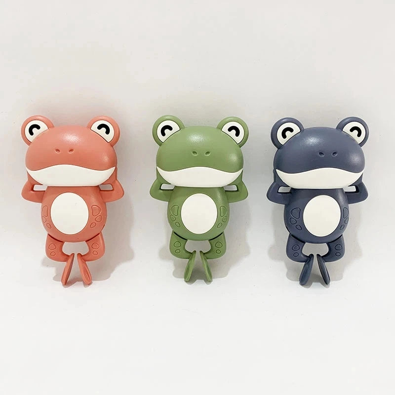 Three ceramic frog toys in peach, green, and gray colors for toddlers.