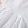 Close-up of a white kids summer cotton dress with a turn-down collar and pleated skirt detail.