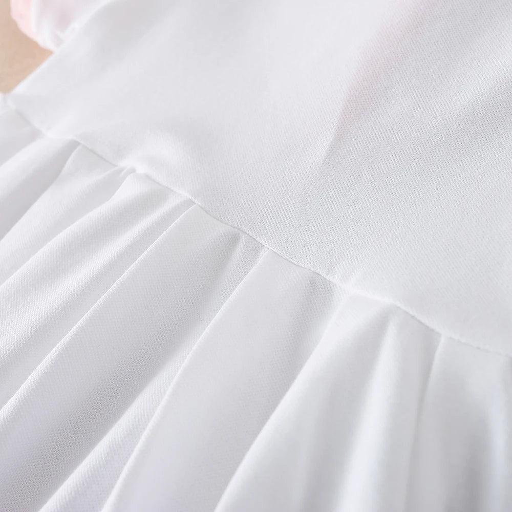 Close-up of a white kids summer cotton dress with a turn-down collar and pleated skirt detail.