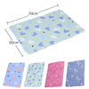 A flat, light blue waterproof baby mattress protector featuring a pattern of small hearts and leaves.