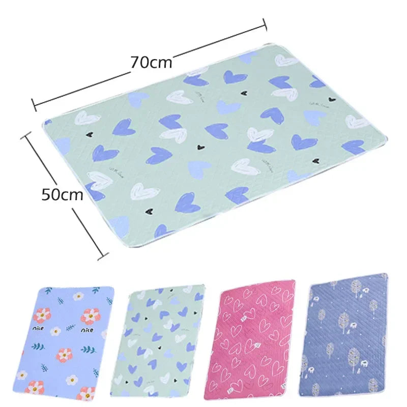 A flat, light blue waterproof baby mattress protector featuring a pattern of small hearts and leaves.