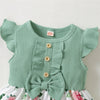 A light mint green ribbed sleeveless top with ruffled sleeves and a bow, worn as part of a floral dress.