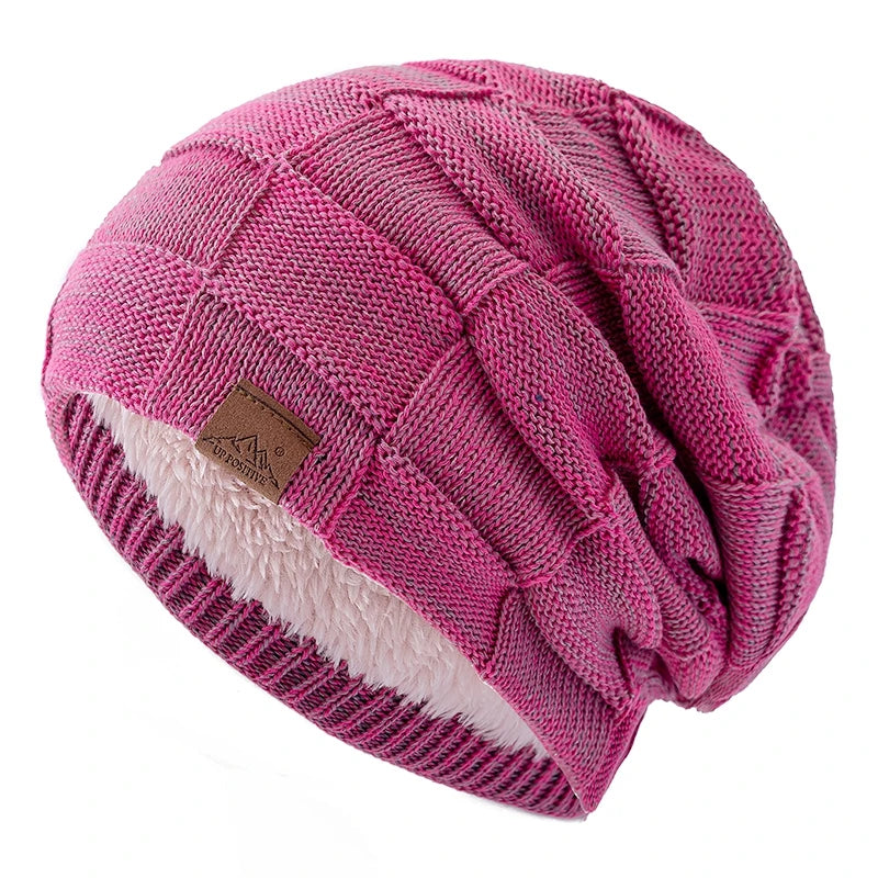 A pink knit beanie with a multicolor pattern and a white sherpa lining.