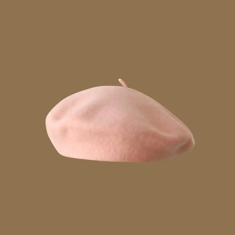 A soft pink classic wool beret hat for women viewed from above.