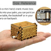 Una pequeña caja de música de madera con manivela que cabe en la palma de la mano.