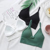 A collection of black, white, and green seamless U-back bralettes with removable pads displayed on a white background.