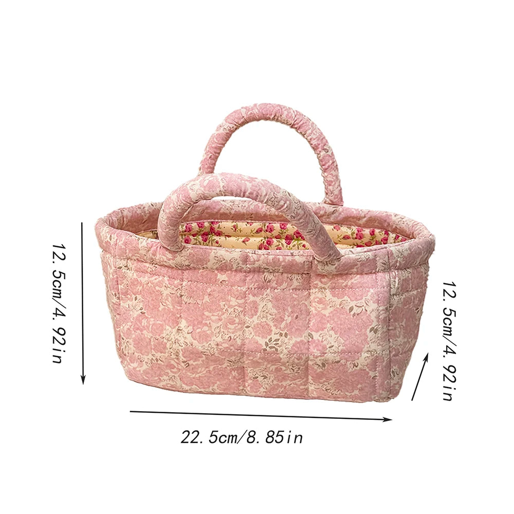 Kurv i rosa quilteblomstermønster med håndtak, 12,5 cm høy og 22,5 cm bred.