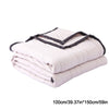 A stack of white breathable cooling throw blankets folded and rolled.