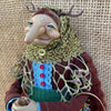 Handcrafted kitchen witch doll with antique charm featuring a face, antlers, and textured clothing.