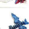 Primer plano de un dragón articulado azul impreso en 3D, figura de escritorio con escamas detalladas.