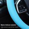 Primer plano de una funda de volante de silicona azul claro en el interior de un coche.